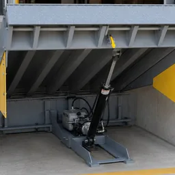 Hydraulic dock leveler in raised position showing the hydraulic cylinder and pump assembly